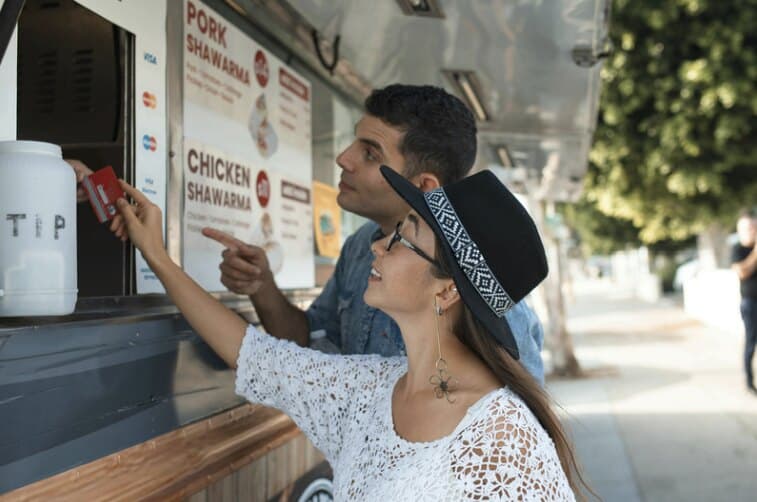 Customers paying by credit card at a food truck window